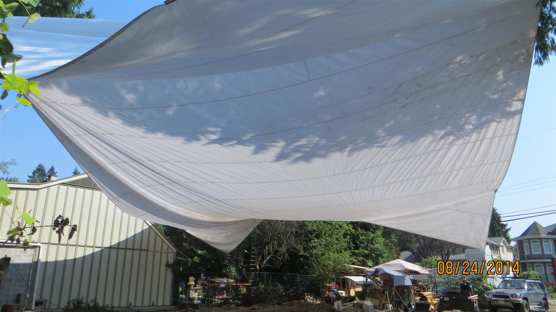 This photo starts to show the scale of this tarp when compared to a 2-Storey house in the background
